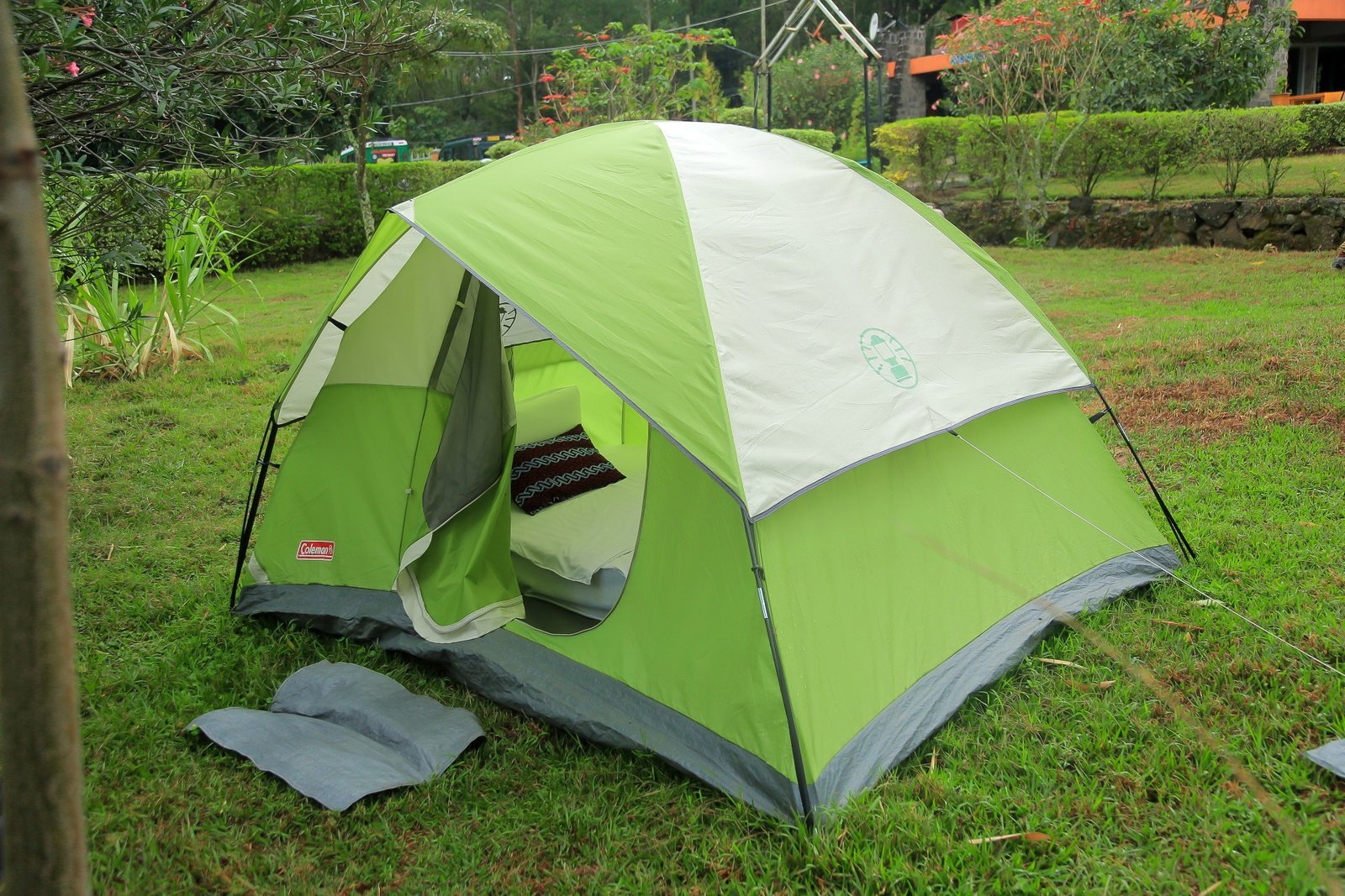 Green and white dome tent pitched on a grassy lawn at the resort