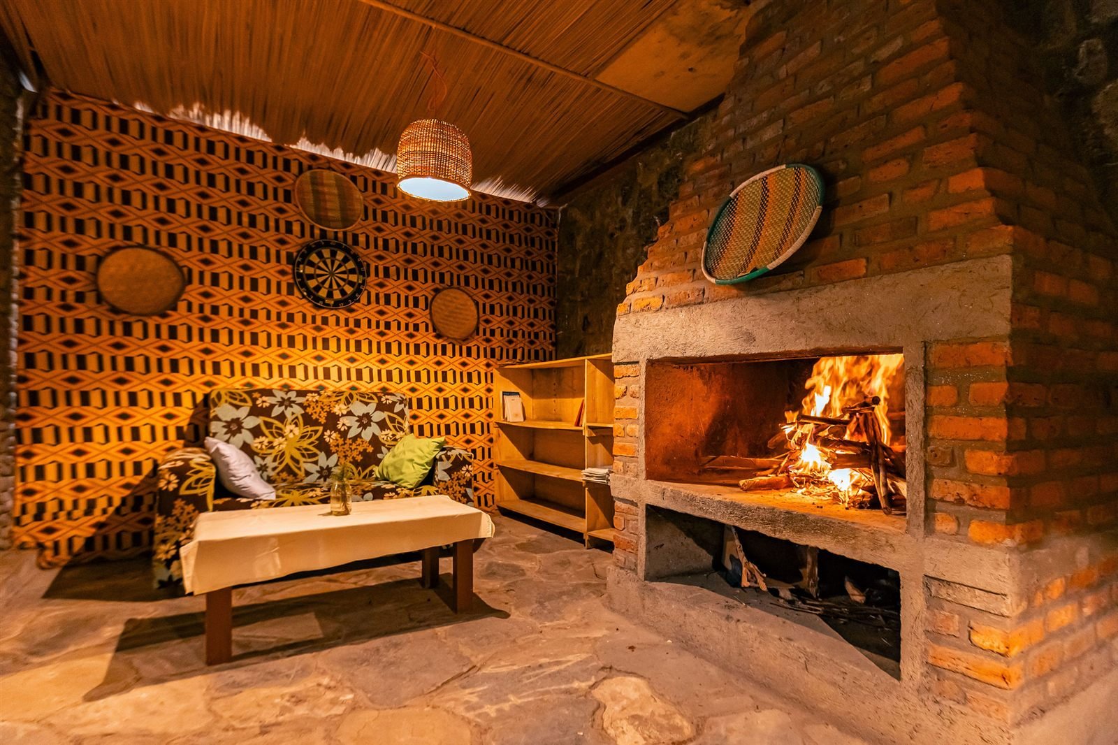Stone fireplace with a lit fire and warm lamps