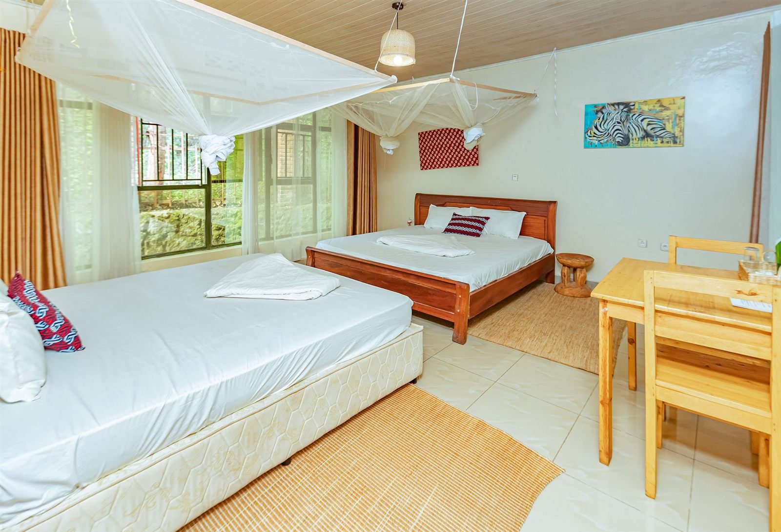 Family room with two beds, white canopy nets and a wooden desk